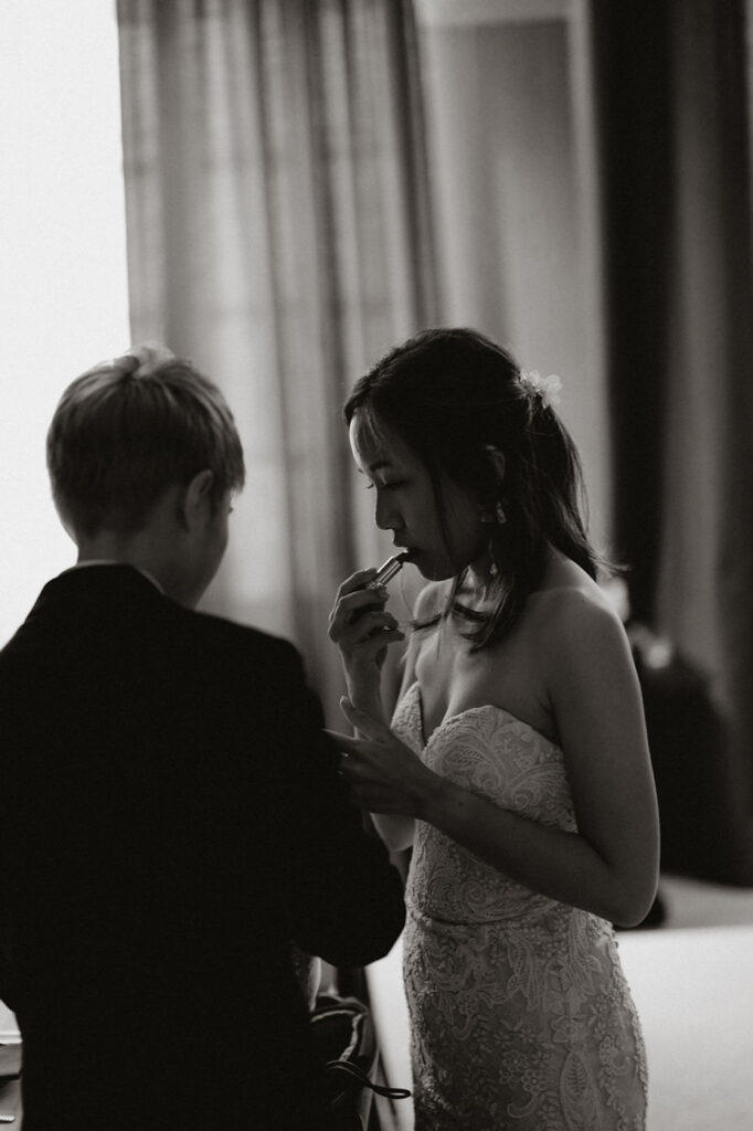 bride puts lipstick on before her iceland wedding ceremony.