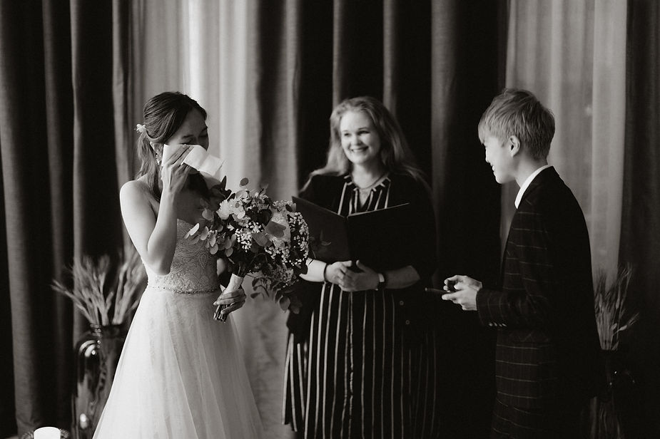 bride wipes tear from her eye during their intimate wedding in iceland.