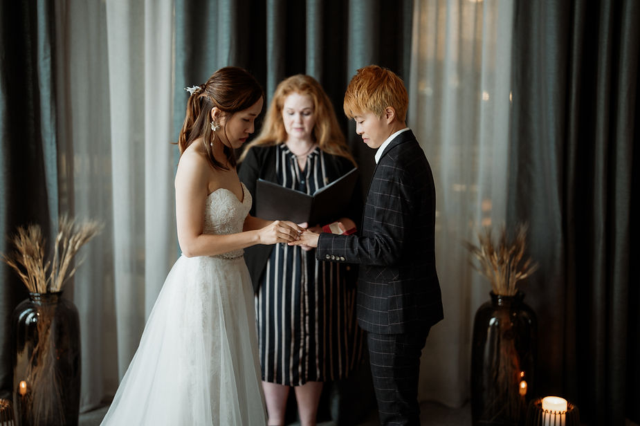 lgbtqi+ couple puts rings on each other during iceland wedding ceremony.
