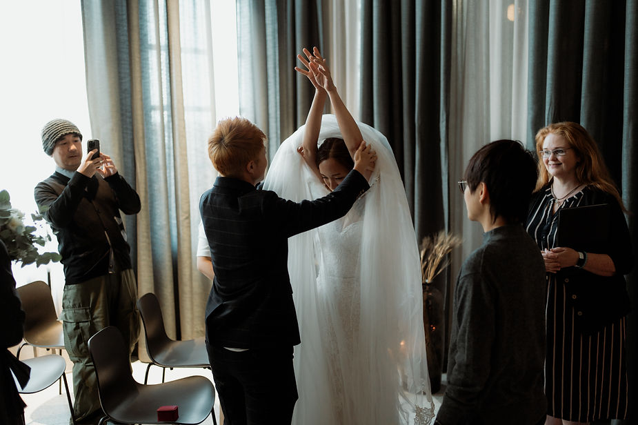 partner helps bride put her dress on during destination wedding in iceland.