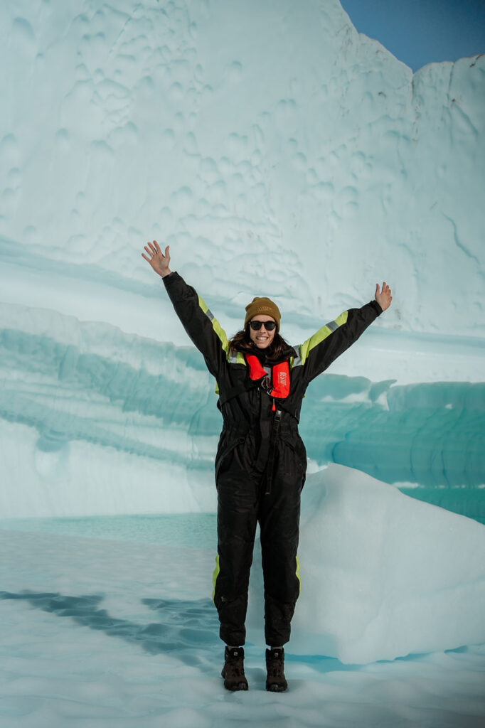 destination wedding photographer stands on glacier in greenland.