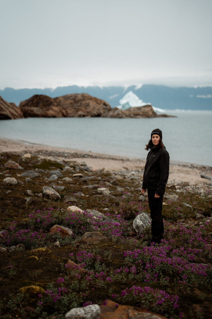 destination wedding photographer stands on greenland coast.