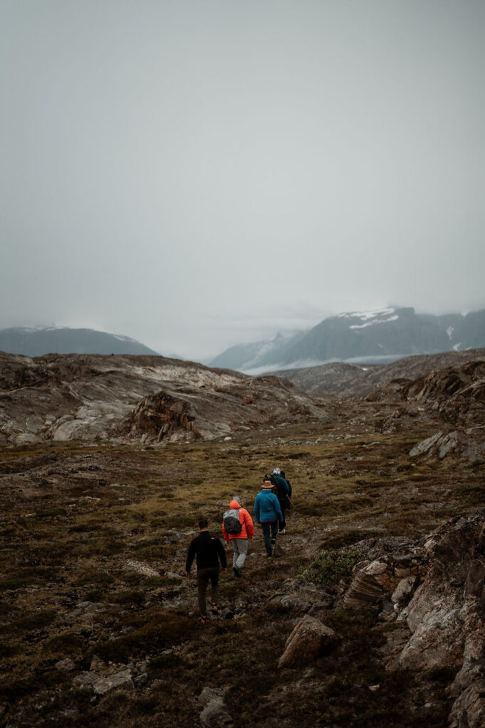 hikers walk through greenland landscape during adventure elopement wedding.