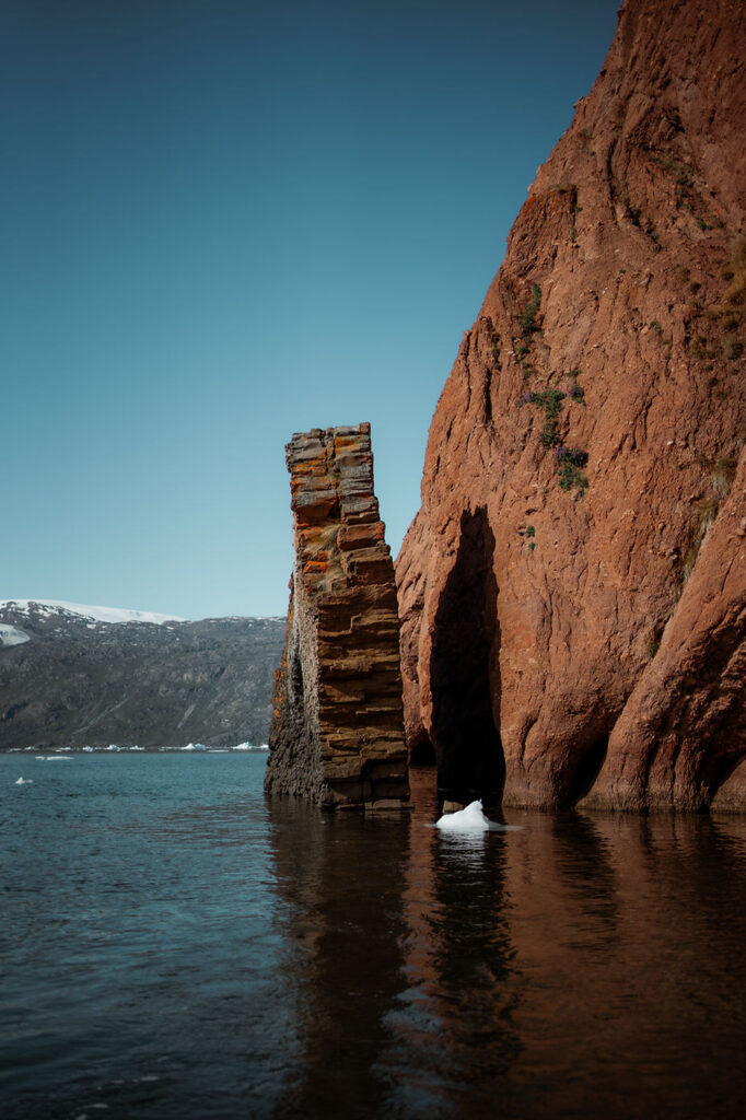 rock edge sticks out of the water during greenland adventure elopement.