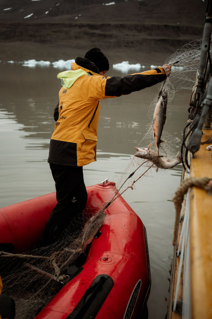 fishermen catch fish during greenland elopement wedding.