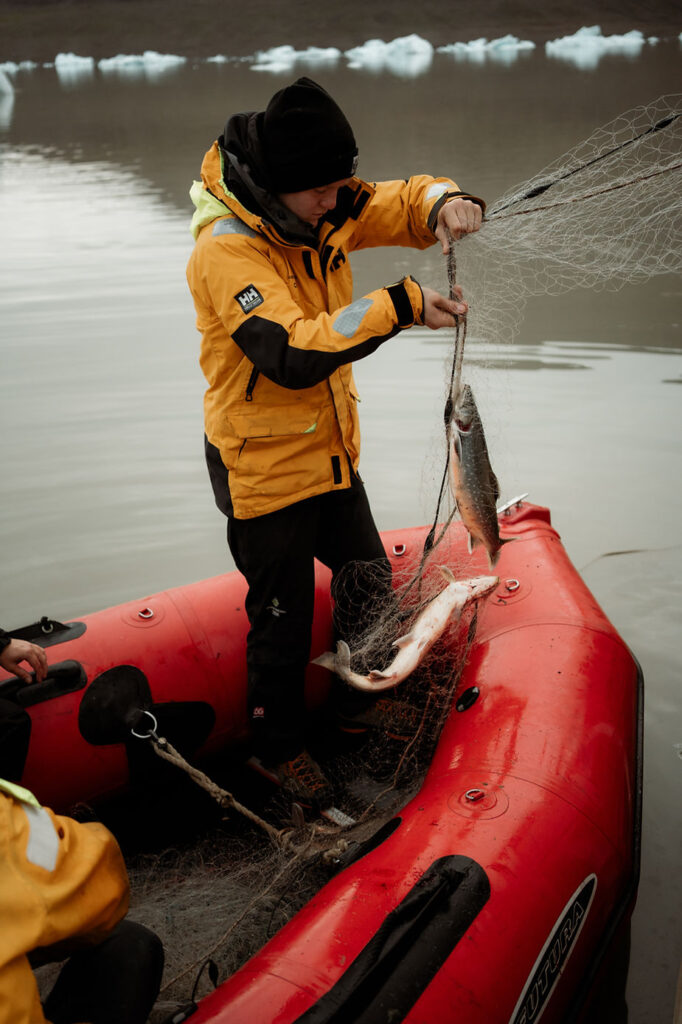 fishermen catch fish during greenland elopement wedding.