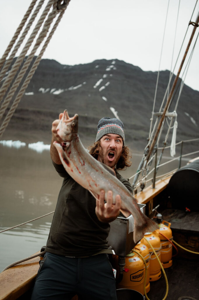 fishermen catch fish during greenland elopement wedding.