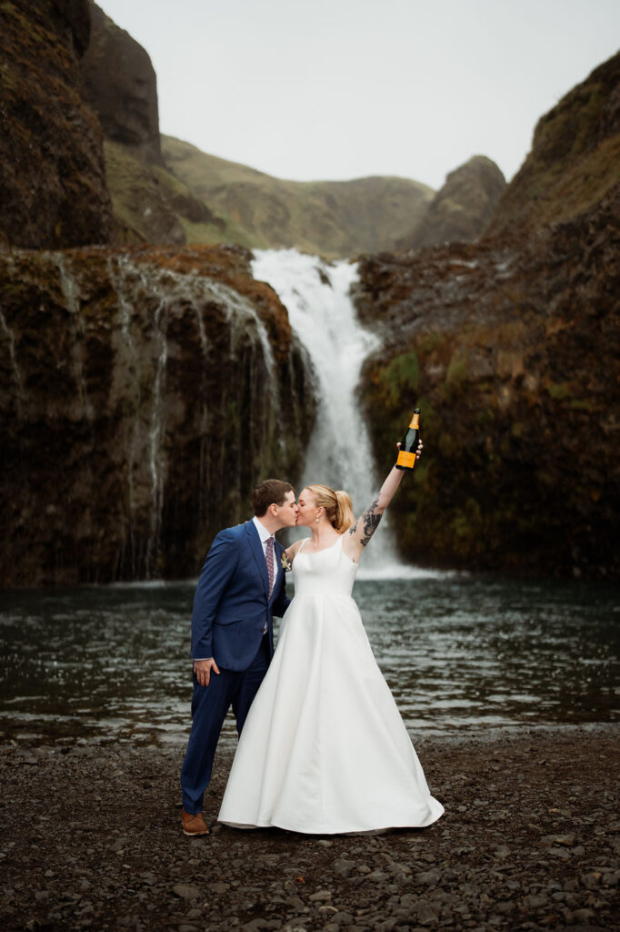 bride and groom pop champagne during iceland wedding adventure.