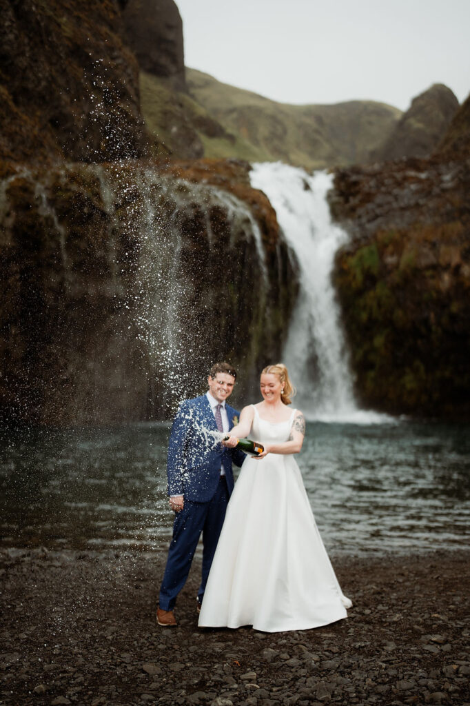 bride and groom pop champagne during iceland wedding adventure.
