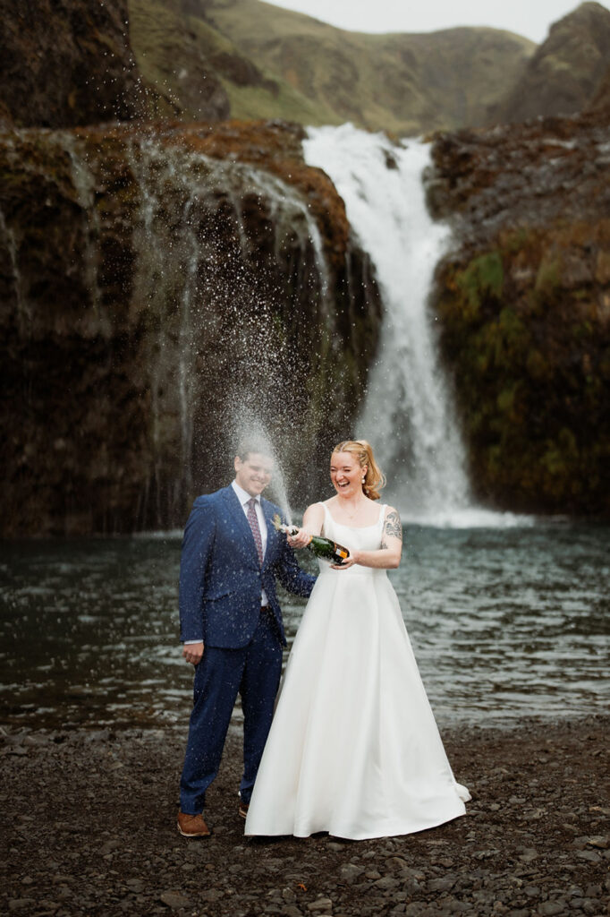 bride and groom pop champagne during iceland wedding adventure.