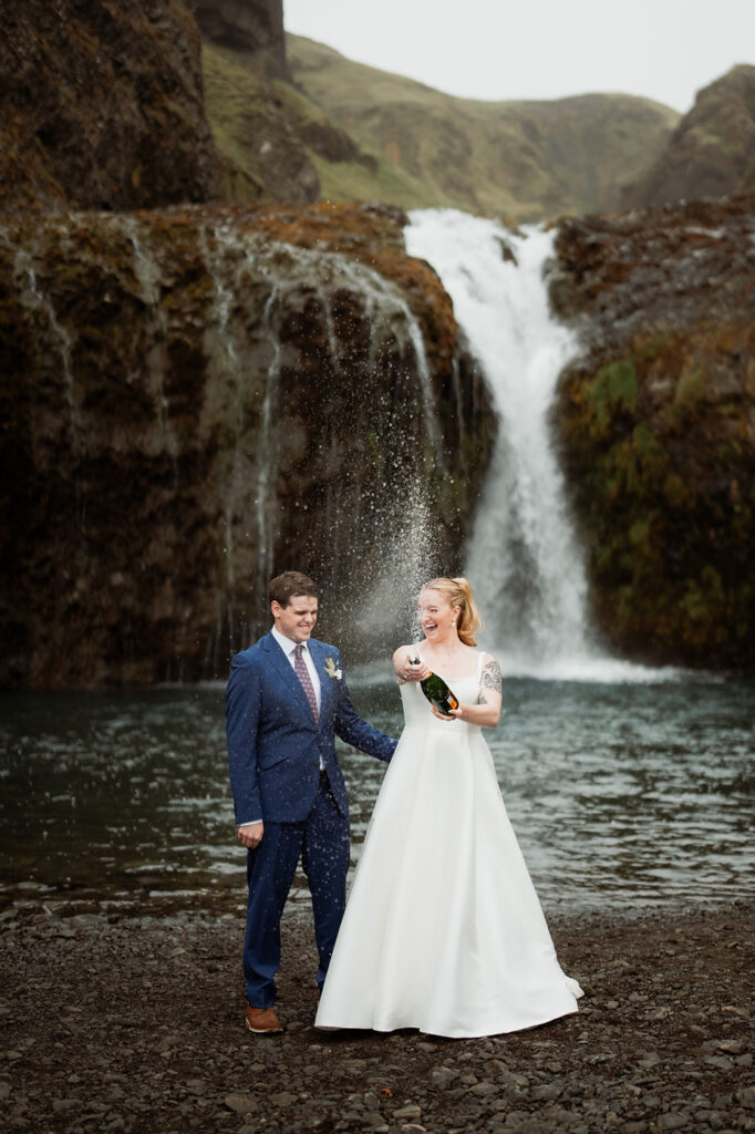 bride and groom pop champagne during iceland wedding adventure.