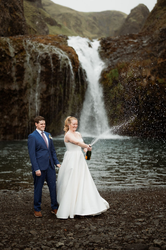 bride and groom pop champagne during iceland wedding adventure.