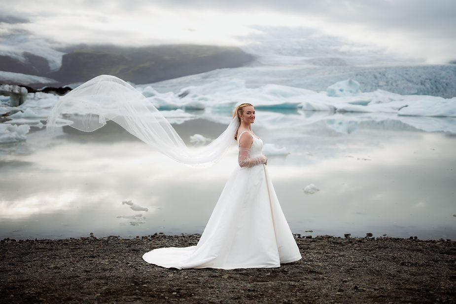 bride poses with veil in the wind for iceland wedding photographer.