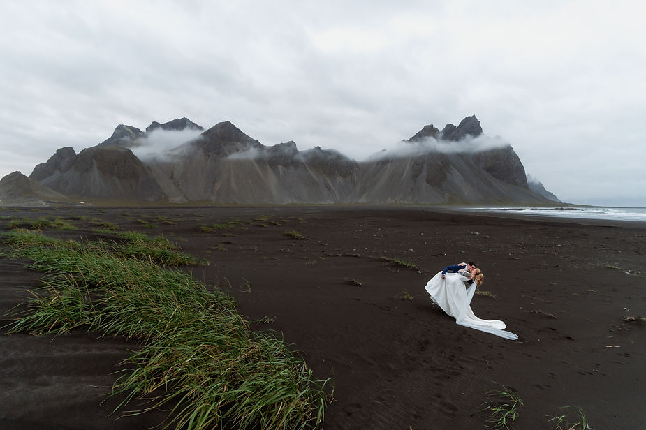 bride and groom kiss on black sand beach during adventure wedding with iceland elopement photographer.