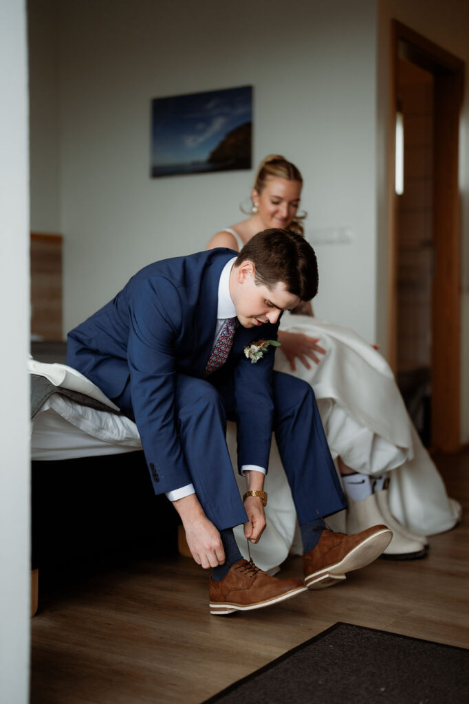 bride and groom put shoes on in preperation for their adventure wedding with iceland wedding photographer.