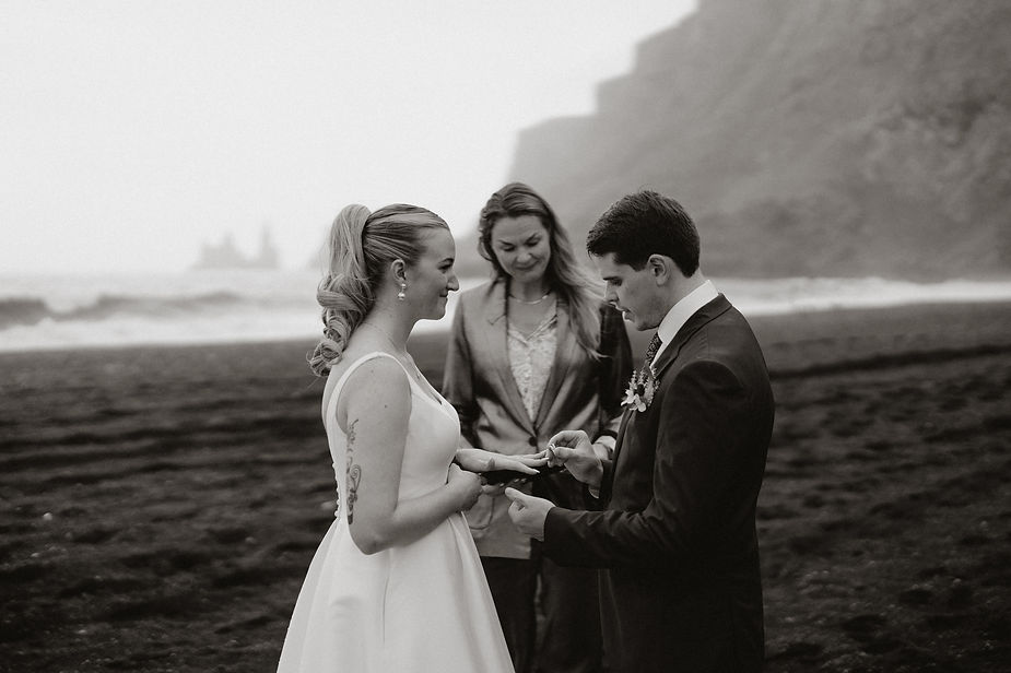 bride and groom put on wedding rings during iceland wedding ceremony.