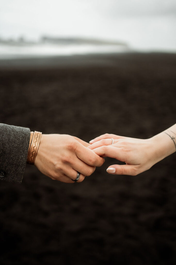 close up image of a bride and groom holding hands.