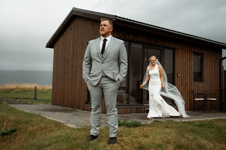 bride walks up behind groom for wedding day first look.