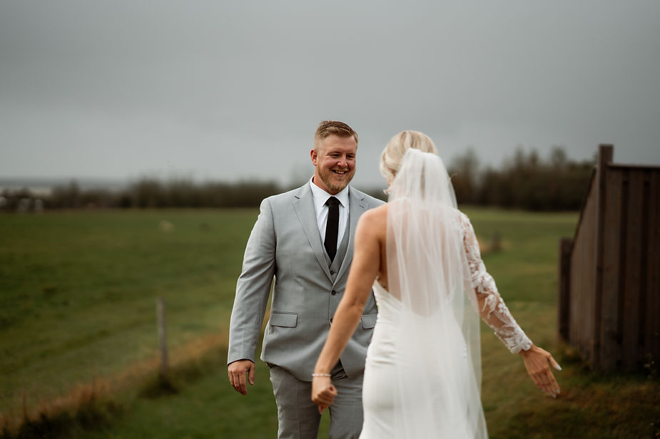 groom turns around and sees bride and smiles.