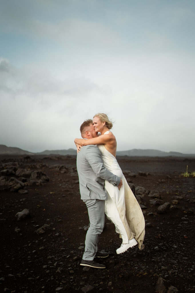 groom lifts up bride during their iceland wedding.