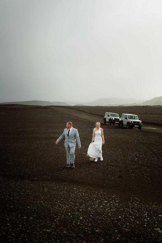 bride and groom wlak in valley during iceland wedding.