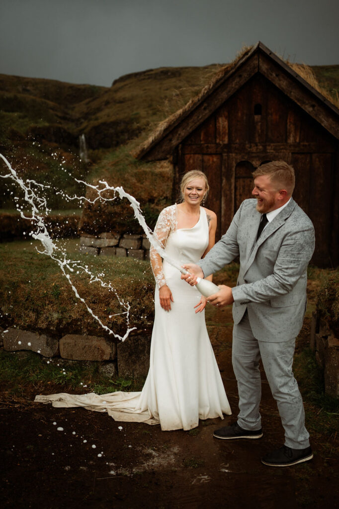 bride and groom pop champagne during iceland wedding day.