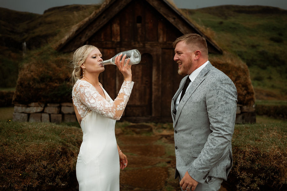 bride drinks from champagne bottle during elopement day in iceland.
