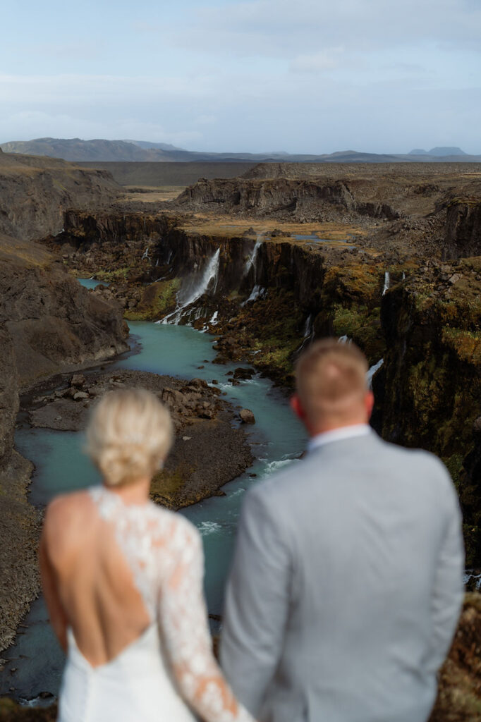 bride and groom look out valley during iceland wedding photos.