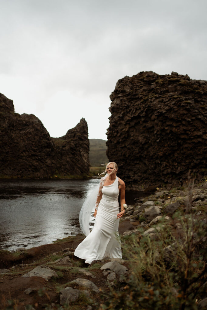 bride walks in iceland valley on her wedding day.