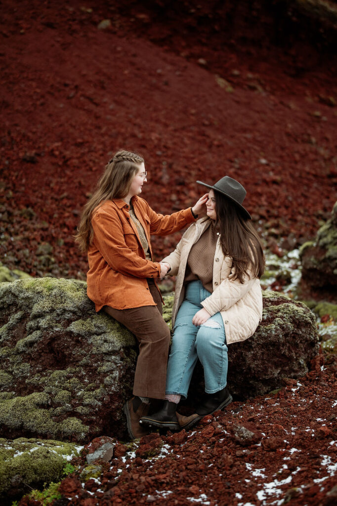 woman puts fiancees hair behind her ear during adventure proposal photos.