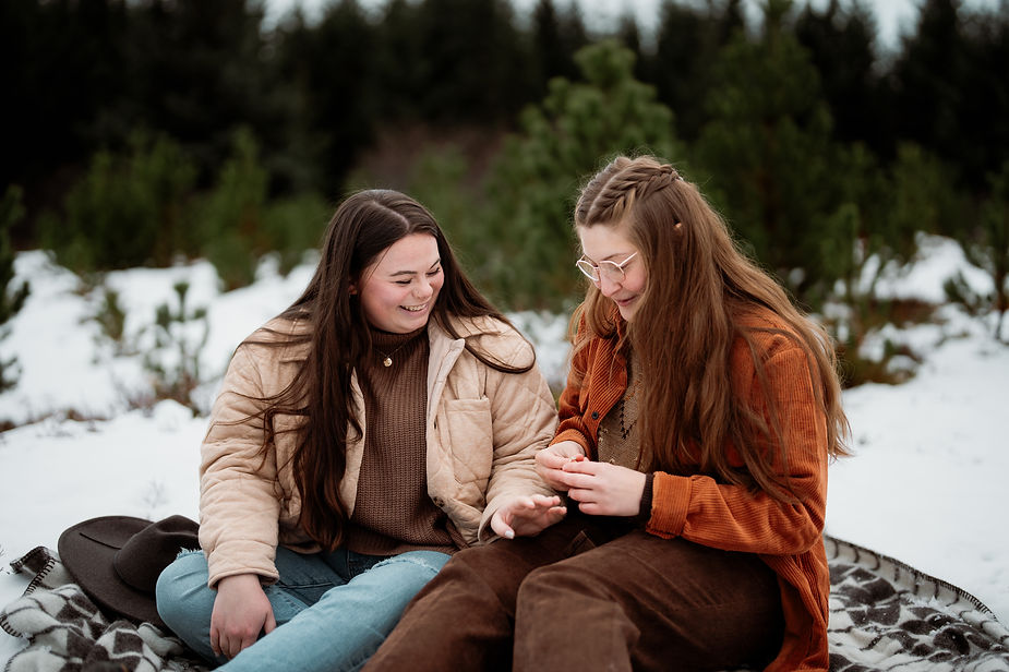 woman holds out hand for other woman to put engagement ring on after iceland proposal.