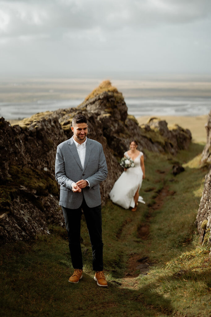 bride walks up behind groom during wedding photos.