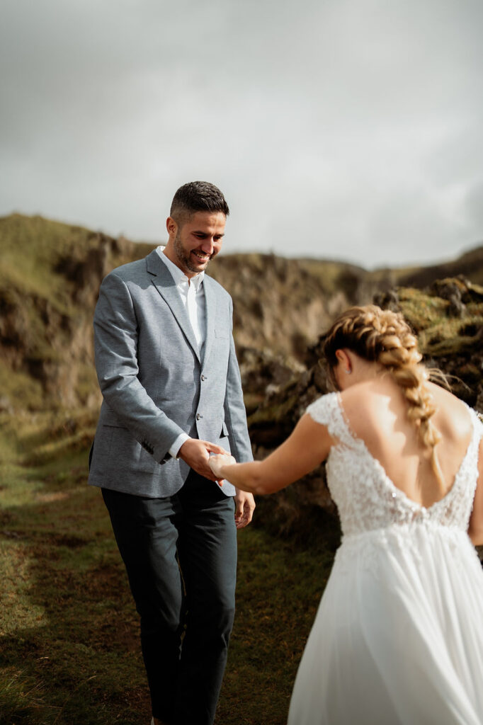 groom smiles at bride and takes her hand.