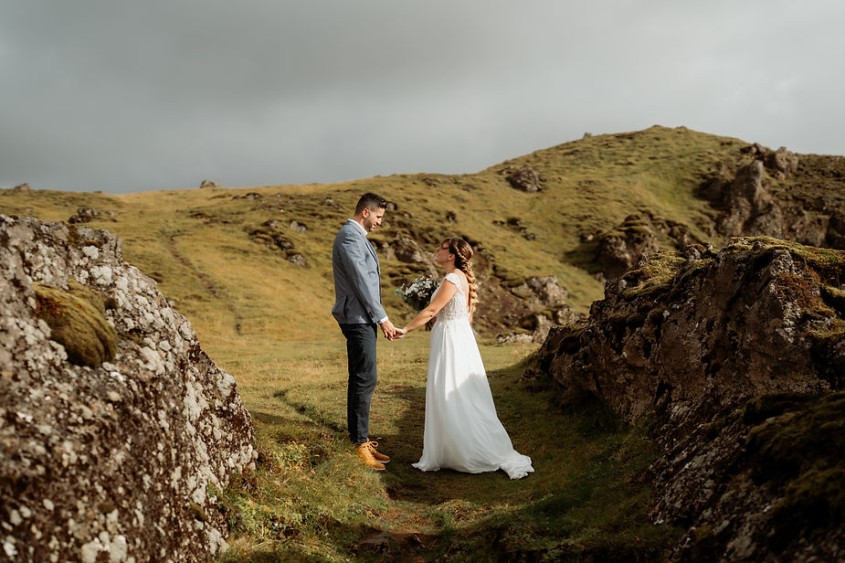 bride and groom hold hands during iceland adventure elopement.
