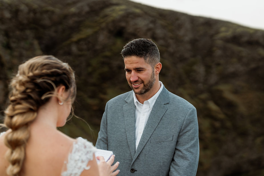 bride and groom read wedding vows during iceland elopement.