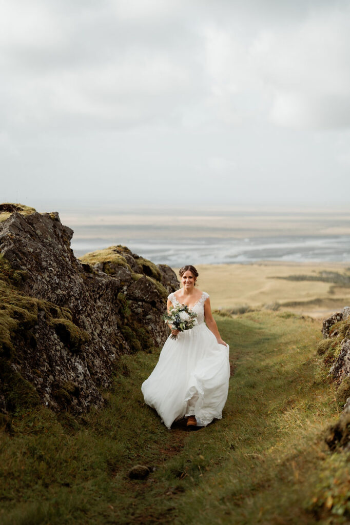 bride walks up grassy aisle in outdoor wedding in iceland.