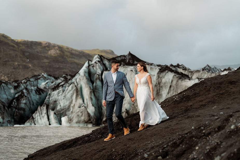 bride and groom walk along glacier during their adventure elopement in iceland.