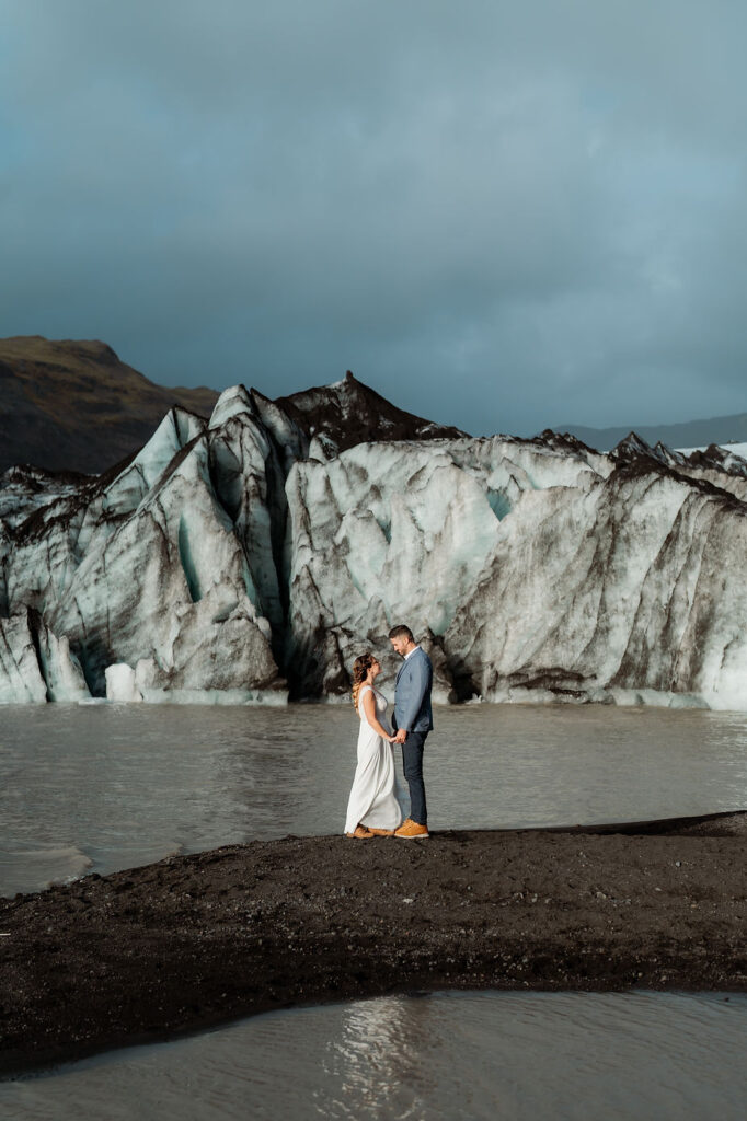 bride and groom stand in front of glacier during their adventure elopement in iceland.