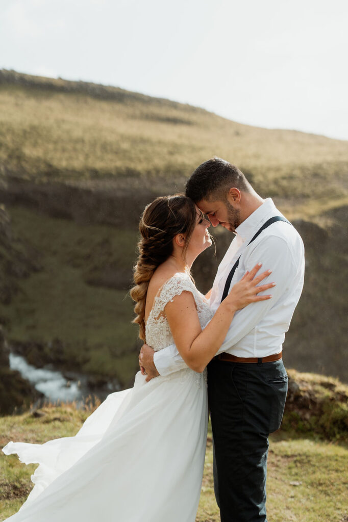 bride and groom press heads together while taking wedding photos.
