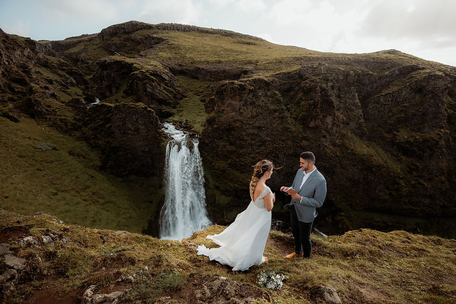 groomreads vows to bride overlooking valley and waterfall in iceland.
