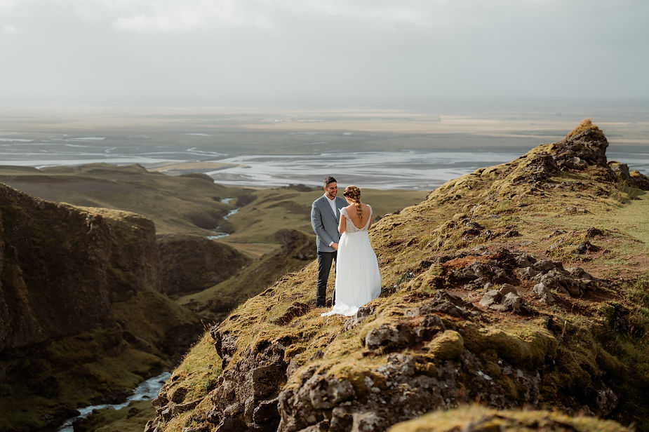 bride and groom read wedding vows overlooking valley in iceland.