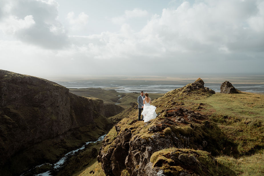 bride and groom stand on edge of valley during iceland elopement.