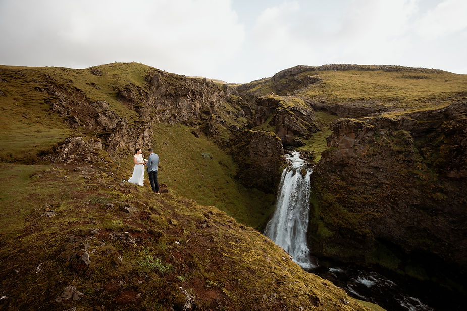 bride and groom stand on edge of valley during their adventure elopement in iceland.