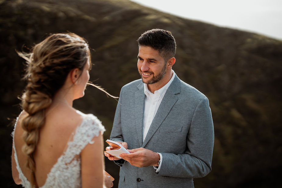 groom reads wedding vows to bride during iceland wedding ceremony.